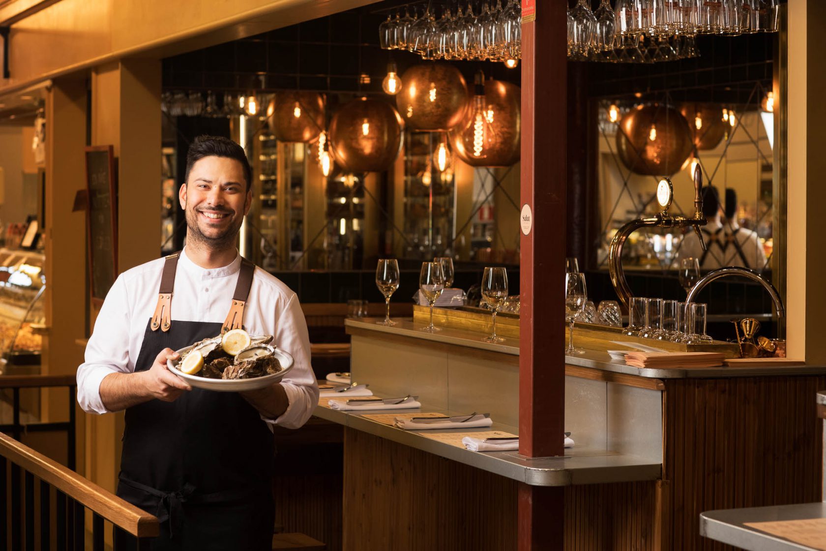 Restaurangpersonal står med en tallrik mat bredvid baren.
